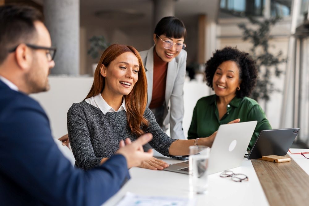 Des professionnels de bureau échangent des idées lors d'une réunion collaborative, favorisant la créativité et le travail d'équipe dans un espace professionnel.